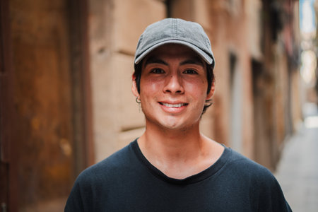 Close up individual portrait of one hispano male smiling and looking at camera with a urban cap....