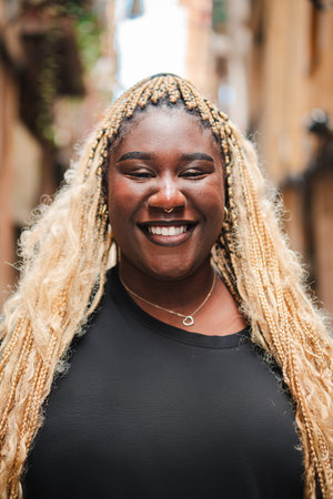 Vertical individual portrait of one african american young adult woman smiling and looking at camera outside. Head shot of a teenage female standingの写真素材