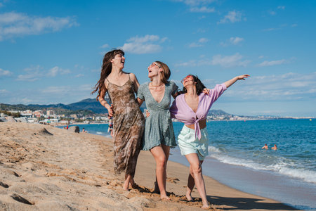 A group of only women walking along the beach, enjoying their summer vacation on the coast. Three...