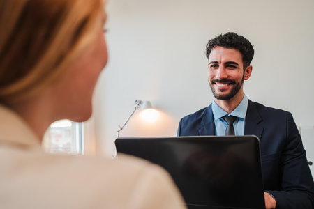 A human resources manager man is conducting a job interview with a new employee. A salesperson, chief financial officer or a stockbroker talking andの写真素材