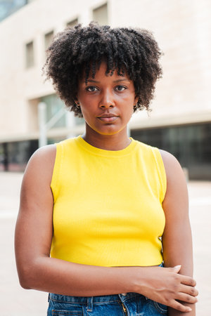Vertical individual portrait of one serious teenage african american girl looking at camera outside. A pensive young adult woman staring front . Proudの写真素材