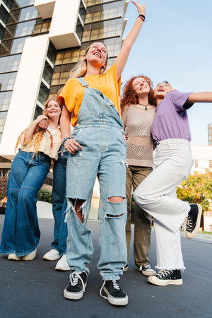 Vertical. Group of only teenage girls having fun on a social gathering outside. Five young women...