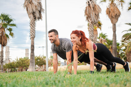 Fit and Motivated Energetic Couple Engaging in a Synchronized Plank Exercise, Pushing Each Other to New Heights of Physical Strength and Enduranceの写真素材
