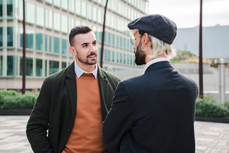 Professional Entrepreneurs Engage in Casual Business Discussion Outside Modern Office Building While Wearing Smart Casual Attire on Cloudy Day. Twoの写真素材