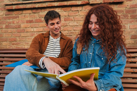 happy young university teenage students reading notebook and studying the lesson together while...