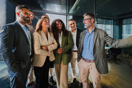 Confident businessman explaining strategy to a diverse team of colleagues in a modern office, fostering teamwork, communication, and collaboration forの写真素材