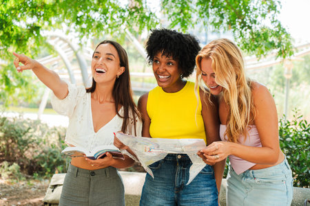 Three Enthusiastic Women Are Engaged In An Exciting Adventure As They Examine A Map Together. They Are Filled With Joy And Laughter While Bonding andの写真素材