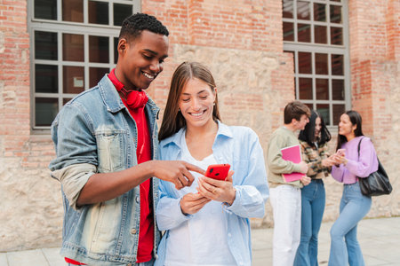 Young friends joyfully sharing exciting moments while using a smartphone to explore engaging...