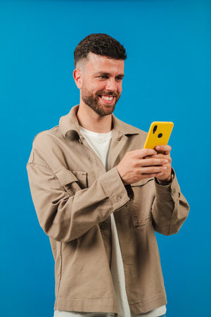 Man joyfully interacting with smartphone while smiling and enjoying the moment with technology