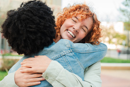Joyful embrace between two happy women sharing a heartfelt moment of connection and friendshipの写真素材