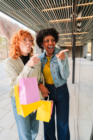 Excited friends share a joyful moment while shopping and pointing out great deals at the storeの写真素材