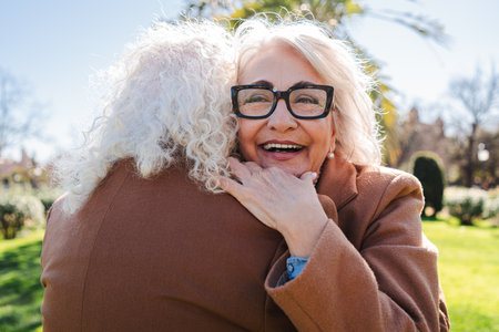 Joyful seniors sharing a heartfelt embrace filled with love and warmth, showcasing the beauty of friendship and connection in a delightful moment ofの写真素材