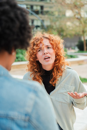 Two women engaged in an intense discussion with emotions running high and tempers flaring during confrontationの写真素材
