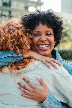Joyful women embracing each other with bright smiles reflecting love and happiness in their heartsの写真素材