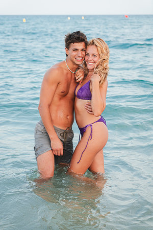 Joyful couple enjoying a romantic moment together while splashing in the refreshing ocean waterの写真素材