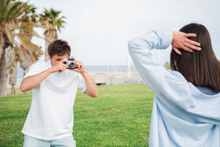 Young couple enjoying a playful moment as they capture memorable memories with a vintage cameraの写真素材