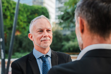 Two professional businessmen engaged in a serious conversation while dressed in formal suits...