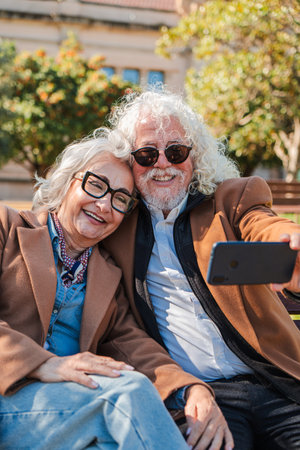 Joyful elderly couple takes a delightful selfie together with a smartphone, capturing cherished...