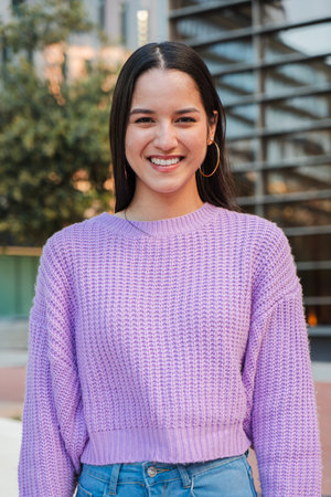 Vertical individual portrait of a joyful and adorable teenage hispanic woman with friendly...