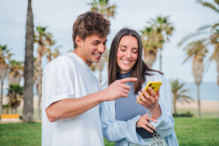 Joyful couple sharing a delightful moment while exploring a smartphone app in a picturesque location