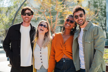 Group of four cheerful friends enjoying their time together with smiles and laughter in the sun