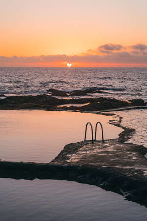 Beautiful natural pools with calmed waters at sunset. Relaxing contemplative vibe. Vertical wide shotの写真素材
