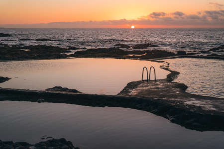 Beautiful natural pools with calmed waters at sunset. Relaxing contemplative vibe. Horizontal wide shotの写真素材