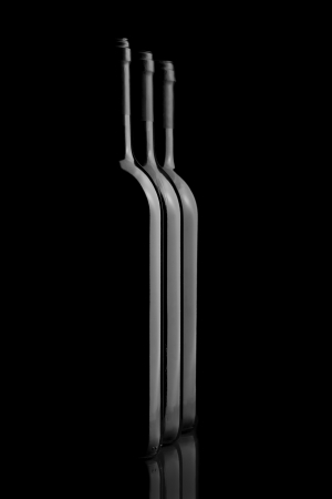 Three elegant wine bottles in a black backgroundの写真素材