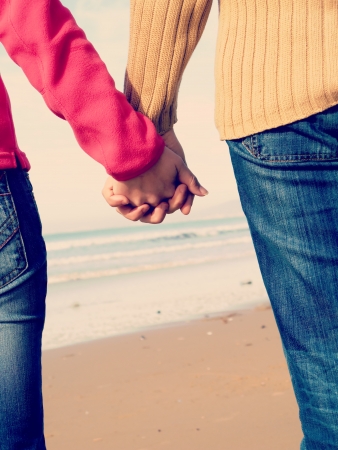 Lovers couple holding hands in beachの写真素材