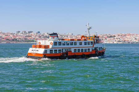 Lisbon, Portugal. August 31, 2014: A Lisbon ferry, known as a Cacilheiro departs from the south margin of the Tagus river in Cacilhas to connect the city of Almada to the capital seen in the horizon.のeditorial素材