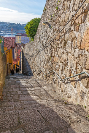 The typical narrow and steep medieval street of the older parts of the city, connecting the Cathedral zone to the Ribeira District of Porto, Portugal. のeditorial素材