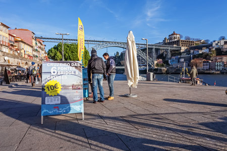 Porto, Portugal. December 29, 2014: Advertisement to the popular 6 Bridges Cruises in the Douro River. Ribeira District, with the typical buildings and Dom Luis I Bridge. Unesco World Heritage Site.のeditorial素材