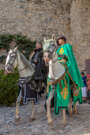 Obidos, Portugal - August 09, 2015: Knights riding white horses in the parade of the Medieval Market reenactment. The Medieval Market festival is very popular among tourists.のeditorial素材