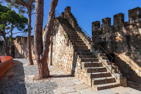 Lisbon, Portugal - February 1, 2017: Castelo de Sao Jorge aka Saint George Castle. Staircase in the defensive walls with a view of the wallwalk, battlements, ramparts, merlons and crenelsのeditorial素材