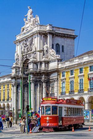 Lisbon, Portugal - April 14, 2018: Carris vintage yellow tram and Rua Augusta Street Triumphal Arch in Praca do Comercio aka Commerce Square or Terreiro do Pacoのeditorial素材