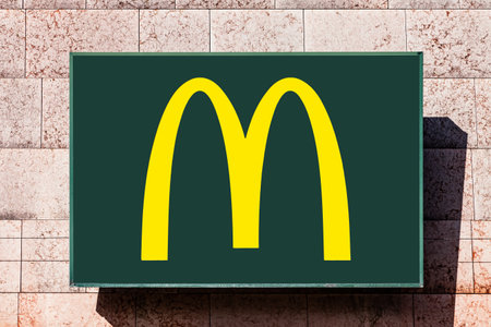 Almada, Portugal - October 24, 2019: Signboard advertising McDonaldâs restaurant with the Golden Arches logo in yellow and green, in a shopping center or shopping mall exterior wallのeditorial素材
