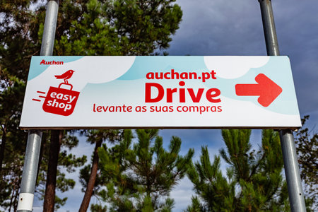 Coina, Portugal - October 23, 2019: Auchan Drive logo or symbol pointing to the pickup area of online purchases. French hypermarket, supermarket or superstore chain. Barreiro Planet Retail Park.のeditorial素材