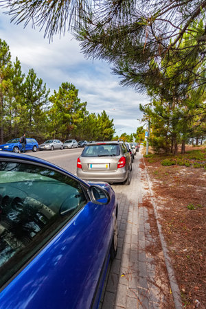 Cars or automobiles parked over the curb into sidewalk, leaving no space for pedestrians in the walkway. Road accessing a suburban railway. Illegal and abusive parkingのeditorial素材
