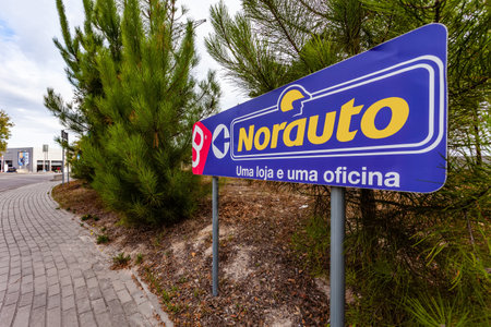 Coina, Portugal - October 23, 2019: Signpost pointing to Norauto car or auto parts shop and service station. Auto repair shop in Barreiro Planet Retail Park. The text says: One store and one workshopのeditorial素材