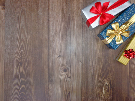 Christmas motifs and celebrations with gifts on a wooden background, with space to place textの写真素材