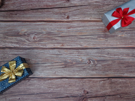 Christmas motifs and celebrations with gifts on a wooden background, with space to place textの写真素材