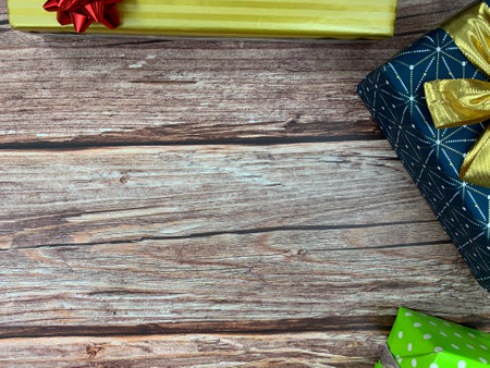 Christmas motifs and celebrations with gifts on a wooden background, with space to place textの写真素材