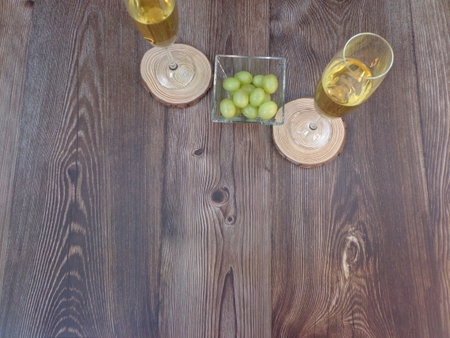Champagne glasses on wooden glasses, with twelve traditional Spanish grapes of old night on a wooden backgroundの写真素材