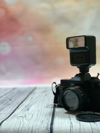Old photo camera with flash mounted on a woodenの写真素材
