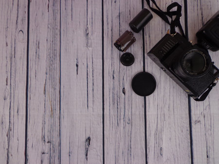 Old photo camera with flash mounted on a woodenの写真素材