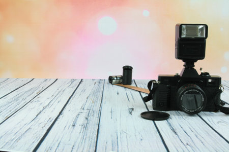 Old photo camera with flash mounted on woodenの写真素材