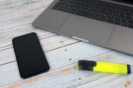 Top view of a computer accompanied by a tablet, a mobile phone and office supplies on vintage wooden backgroundの写真素材