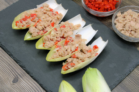 Endives dish filled with tuna, red pepper and onionの写真素材