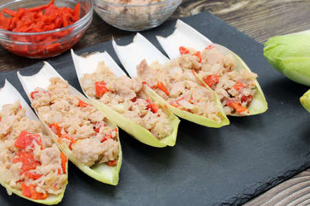 Endives dish filled with tuna, red pepper and onionの写真素材