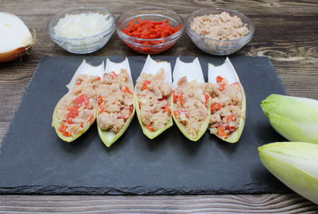 Endives dish filled with tuna, red pepper and onionの写真素材